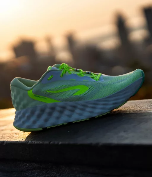 Chaussure de course verte au coucher du soleil.