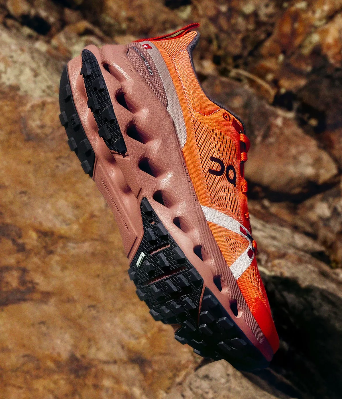 Chaussure sport orange sur rochers.