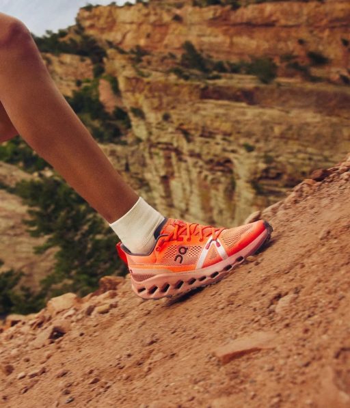 Personne courant sur une pente rocheuse avec chaussures rouges.