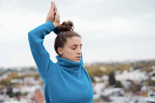 Femme pratiquant yoga en pull bleu