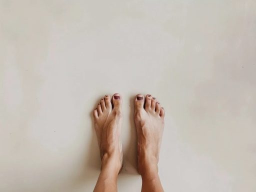 Deux pieds nus sur sol clair.