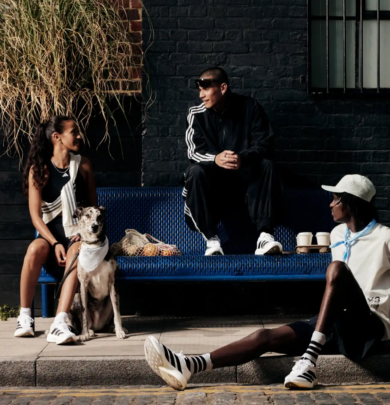 Trois personnes avec un chien assis sur un banc.