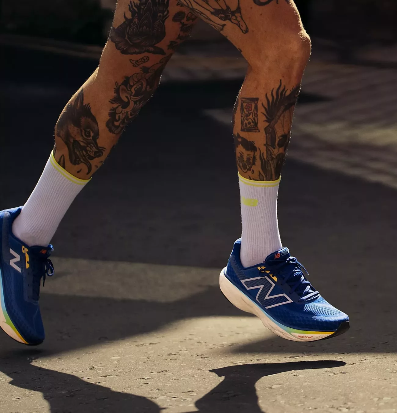 Courir avec chaussures bleues, jambes tatouées.