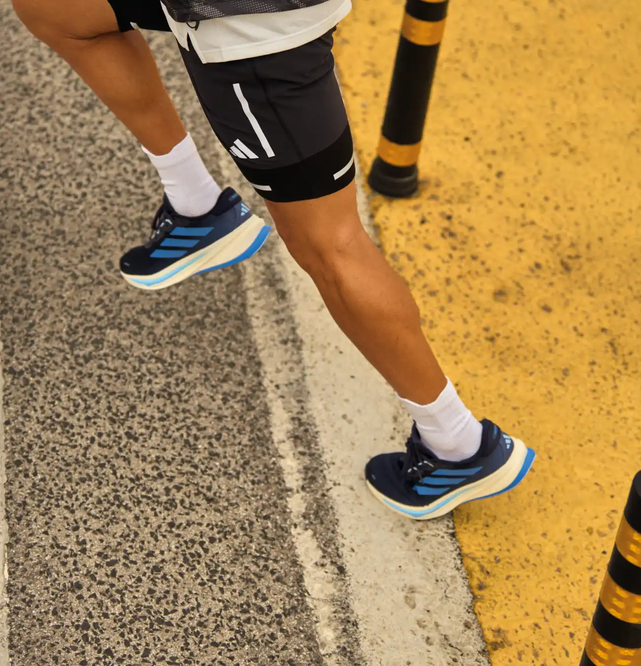 Jambes d'un coureur sur la route.