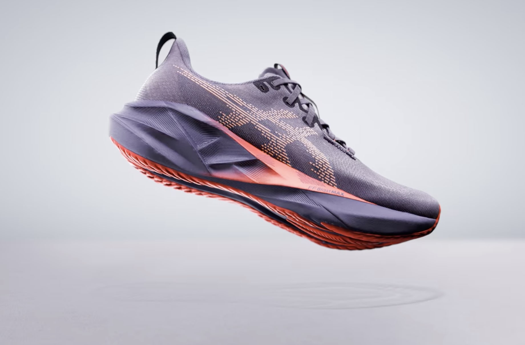 Chaussure de course grise et orange en lévitation.