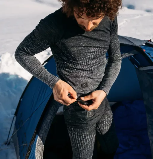 Personne en sous-vêtements thermiques près d'une tente.