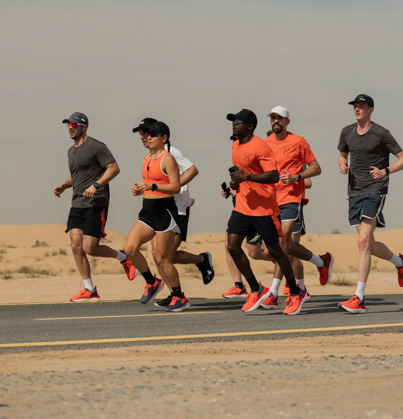 Groupe de coureurs sur une route désertique.