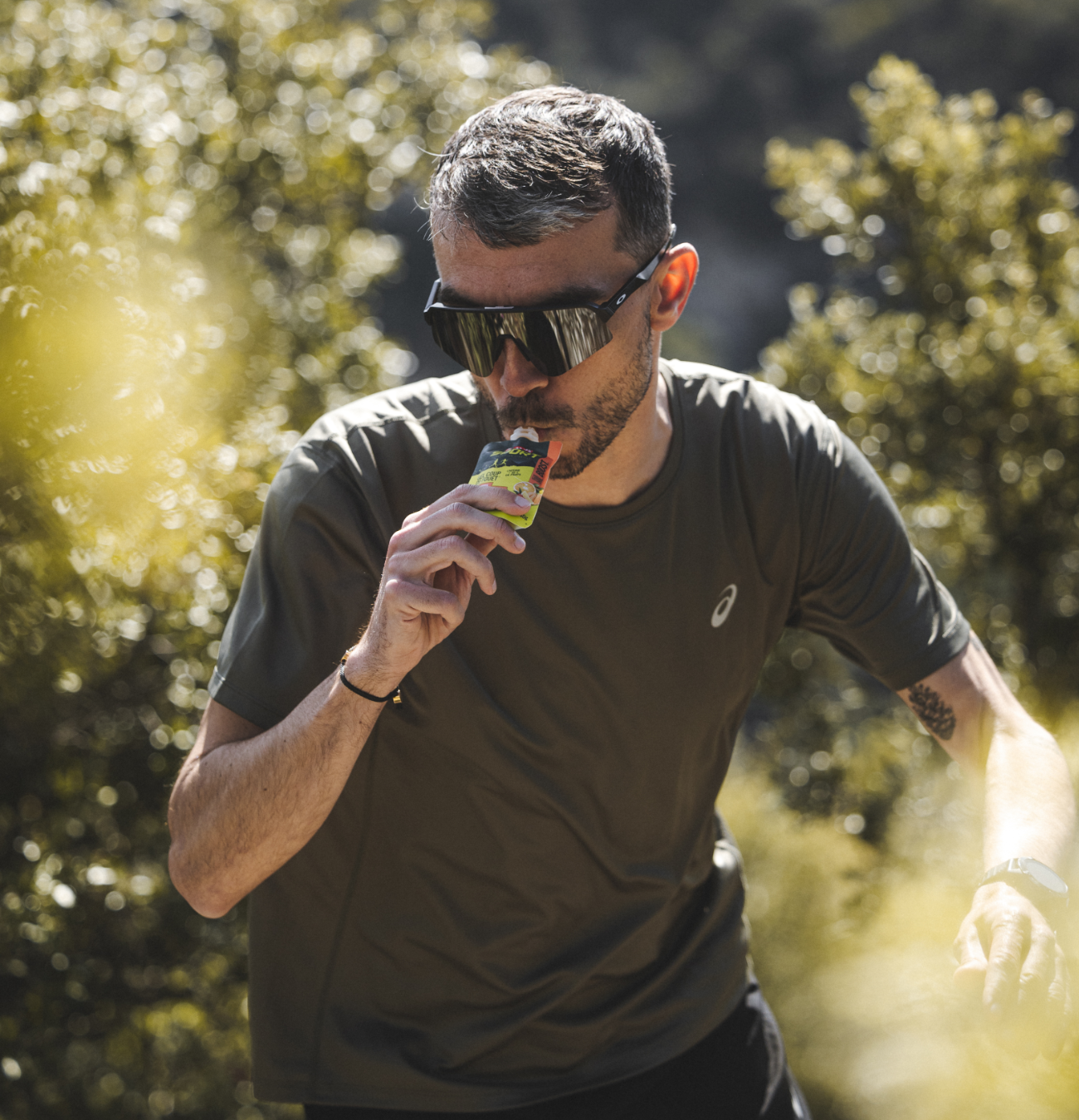 Homme mangeant en plein air, portant des lunettes de sport.