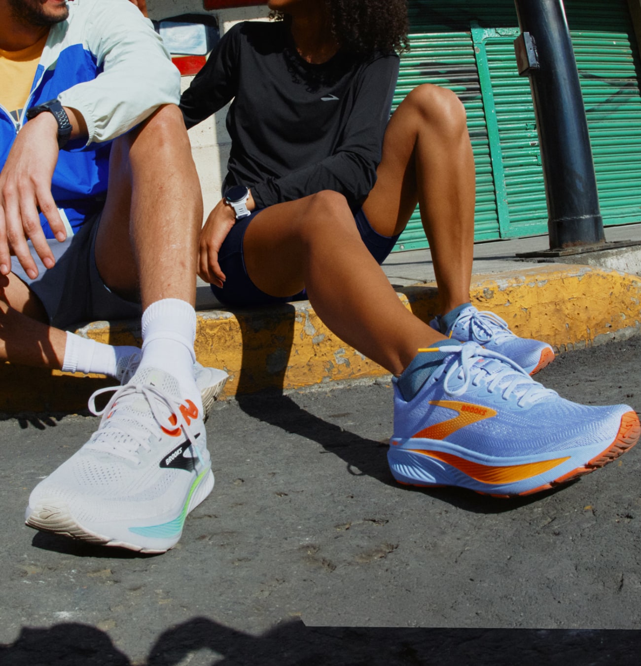 Deux personnes assises, chaussettes et baskets visibles.