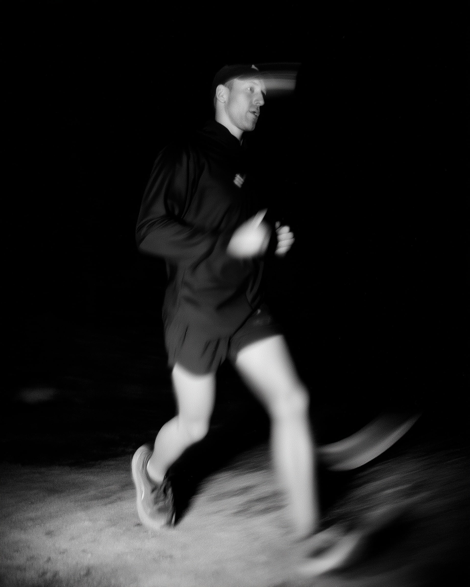 Homme courant la nuit en mouvement flou.