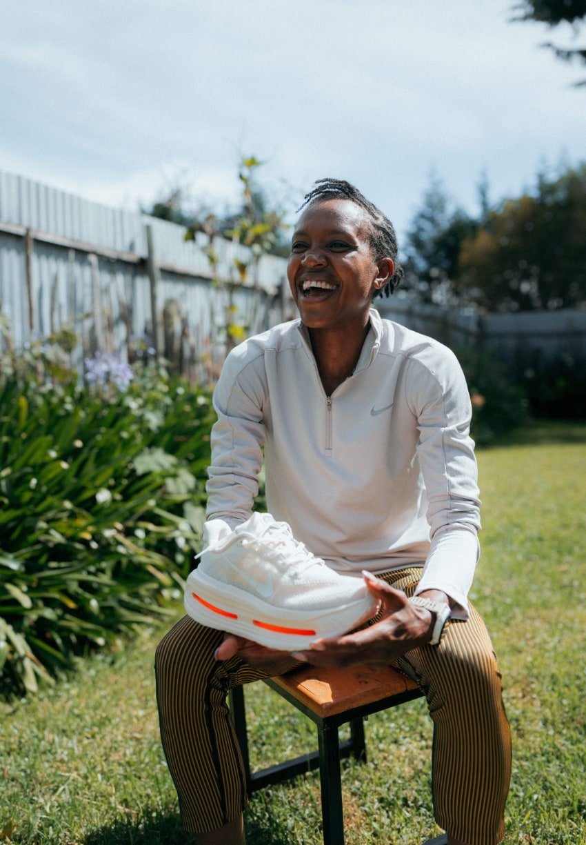 Personne souriant avec chaussures blanches Nike.