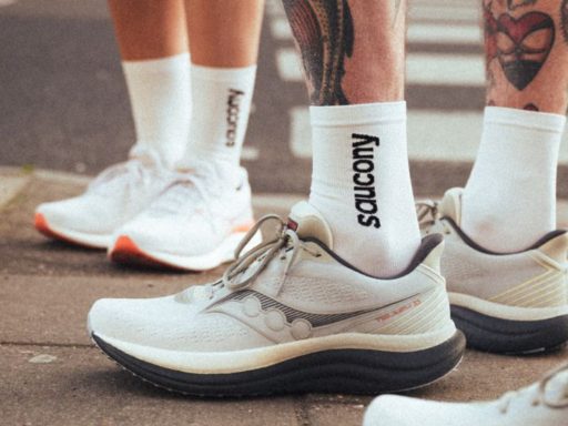Baskets blanches Saucony sur trottoir urbain.