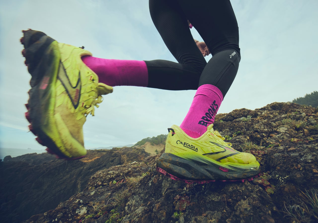 Coureur sur sentier rocheux avec chaussures jaunes.
