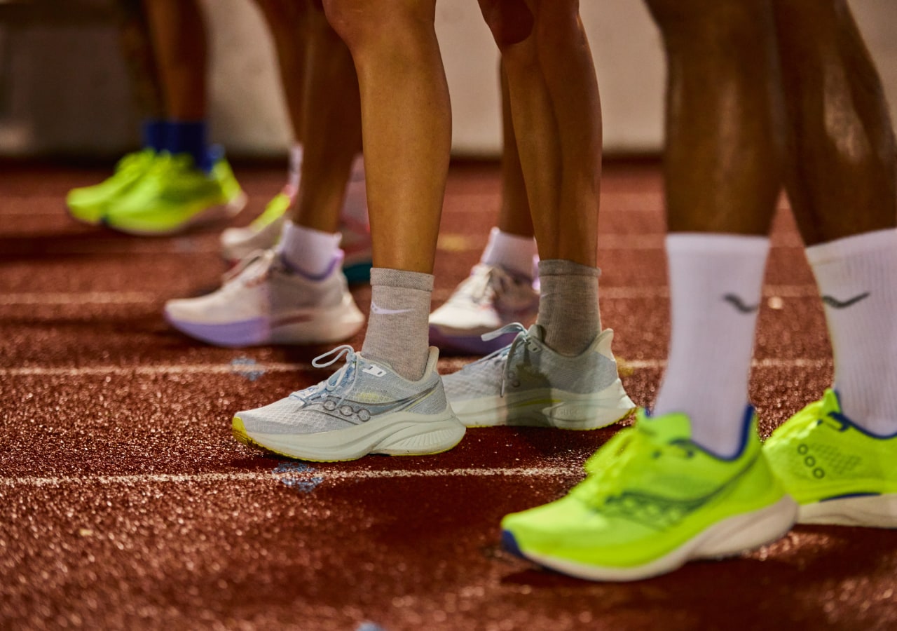 Pieds de coureurs sur une piste d'athlétisme.