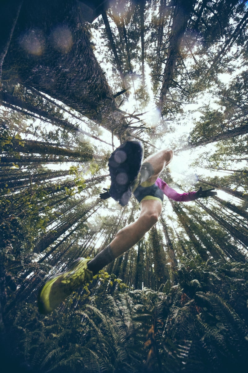 Personne courant dans une forêt vue de dessous.