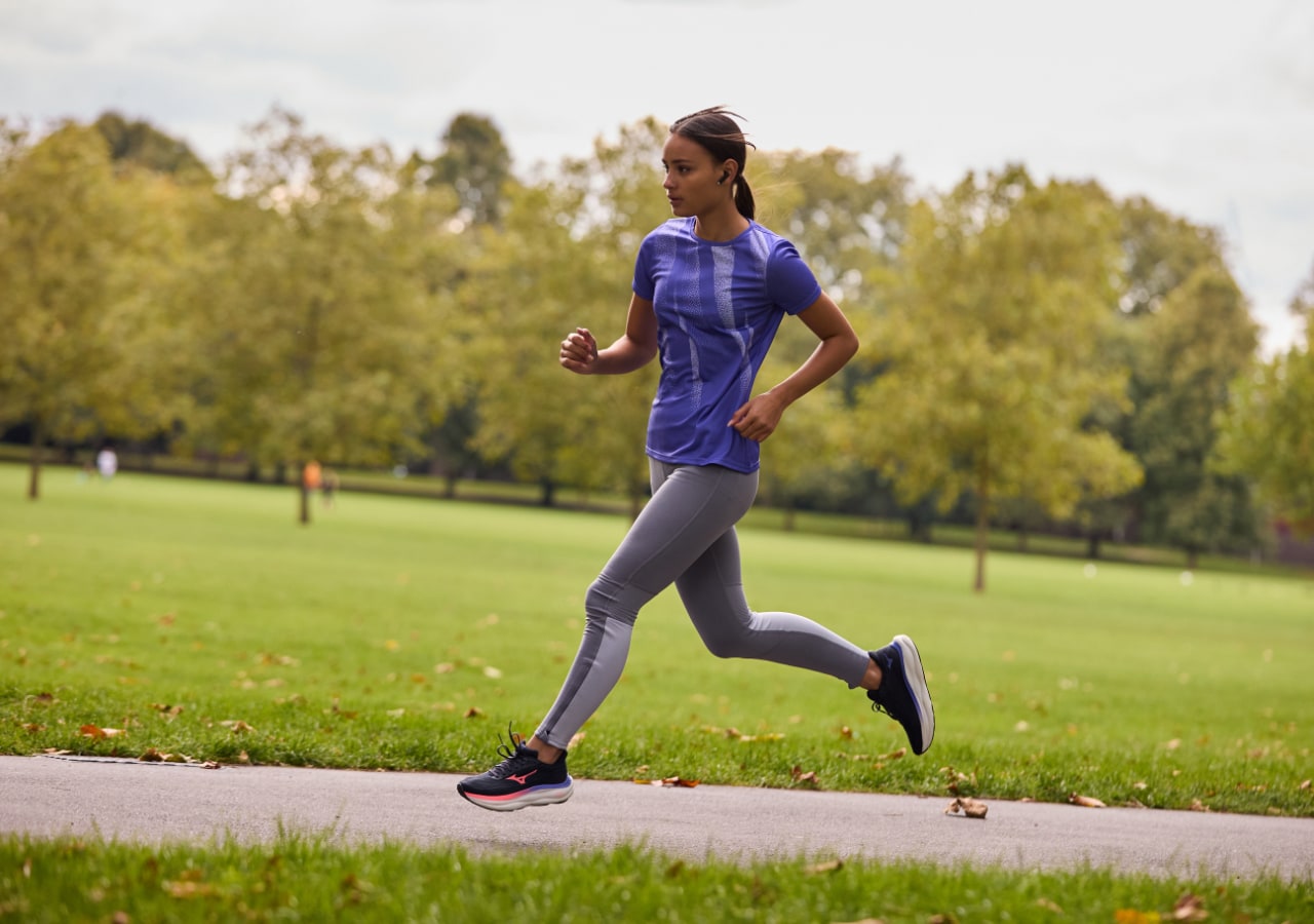 Personne courant dans un parc verdoyant, tenue sportive.