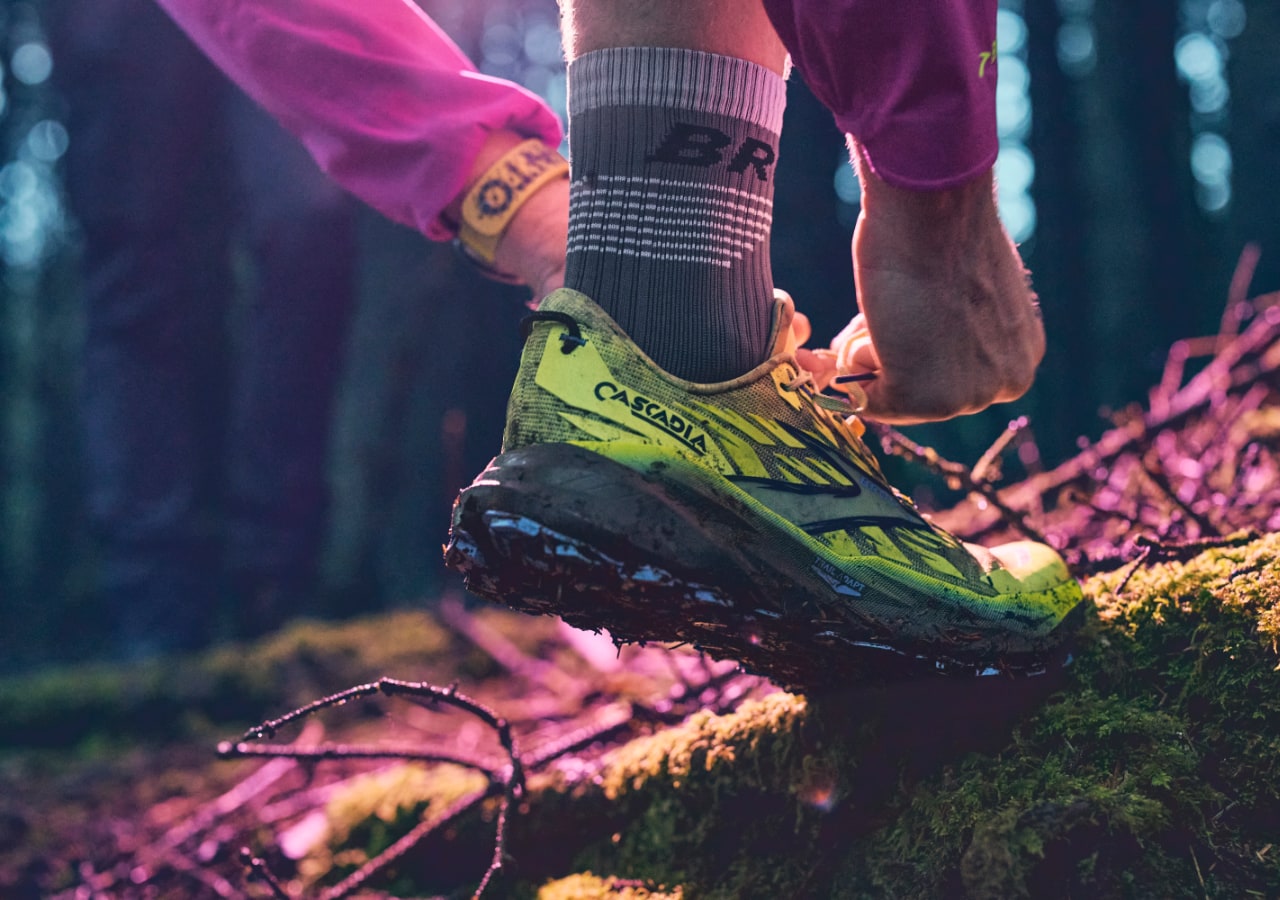 Coureur ajustant ses chaussures en forêt.