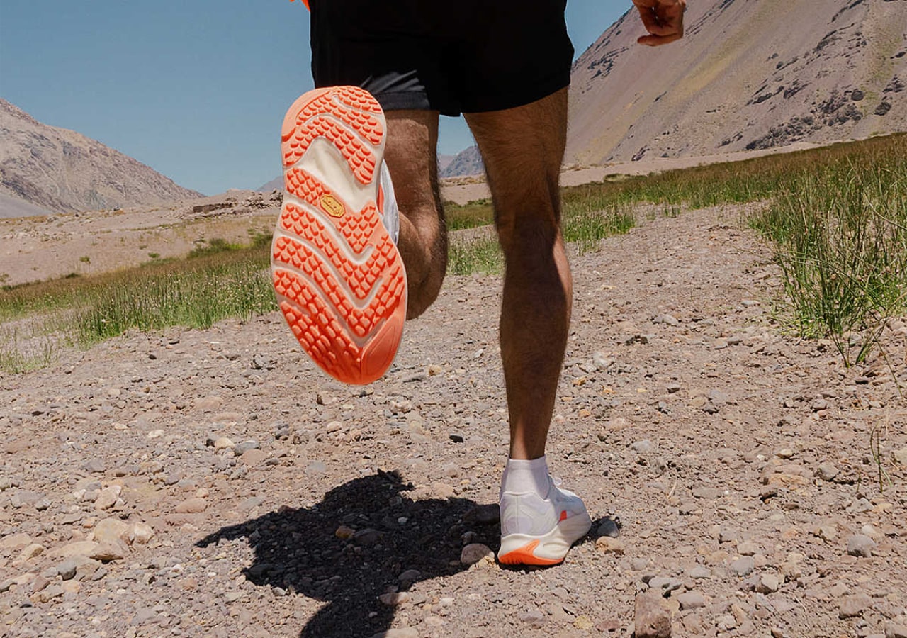 Personne courant sur chemin rocheux en montagne. merrell promorph