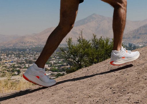 Personne court en montée avec des baskets blanches. merrell promorph