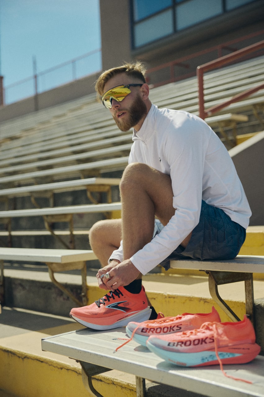 Homme attachant ses chaussures de sport sur un banc. brooks hyperion max 3