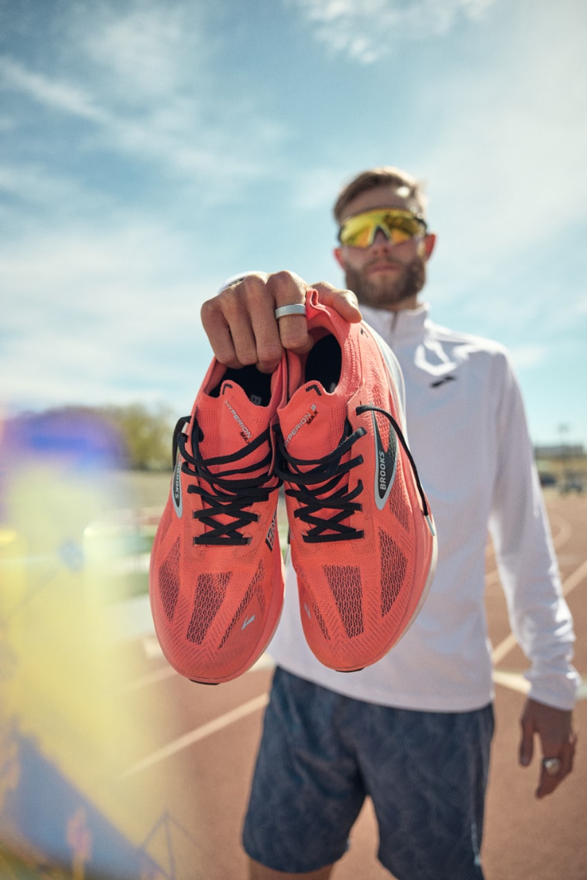 Homme présentant des chaussures de course orange. brooks hyperion max 3