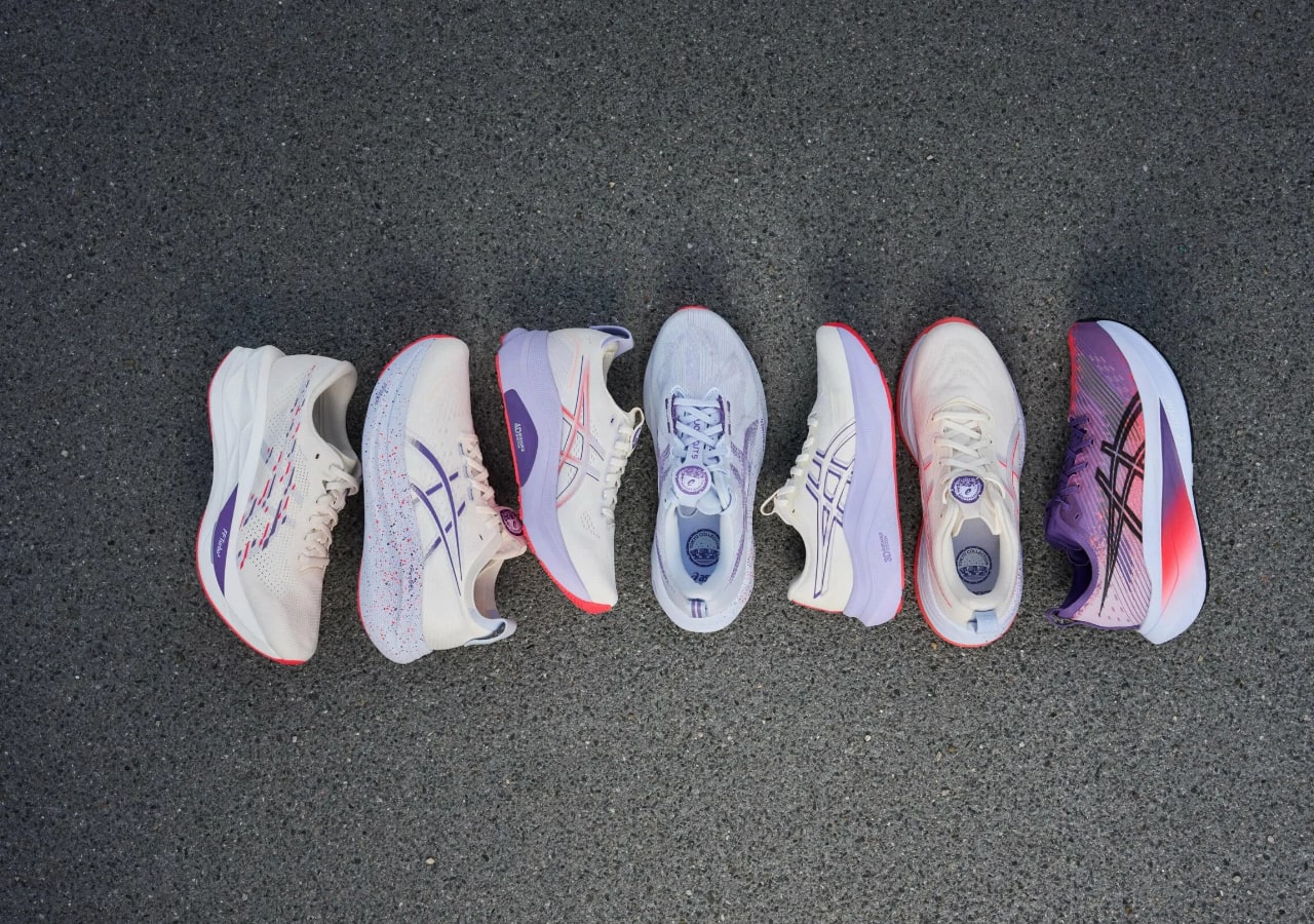 Six paires de chaussures de course alignées sur l'asphalte.