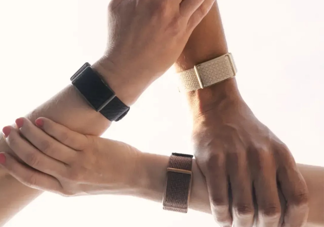 Trois poignets avec des bracelets entrelacés.