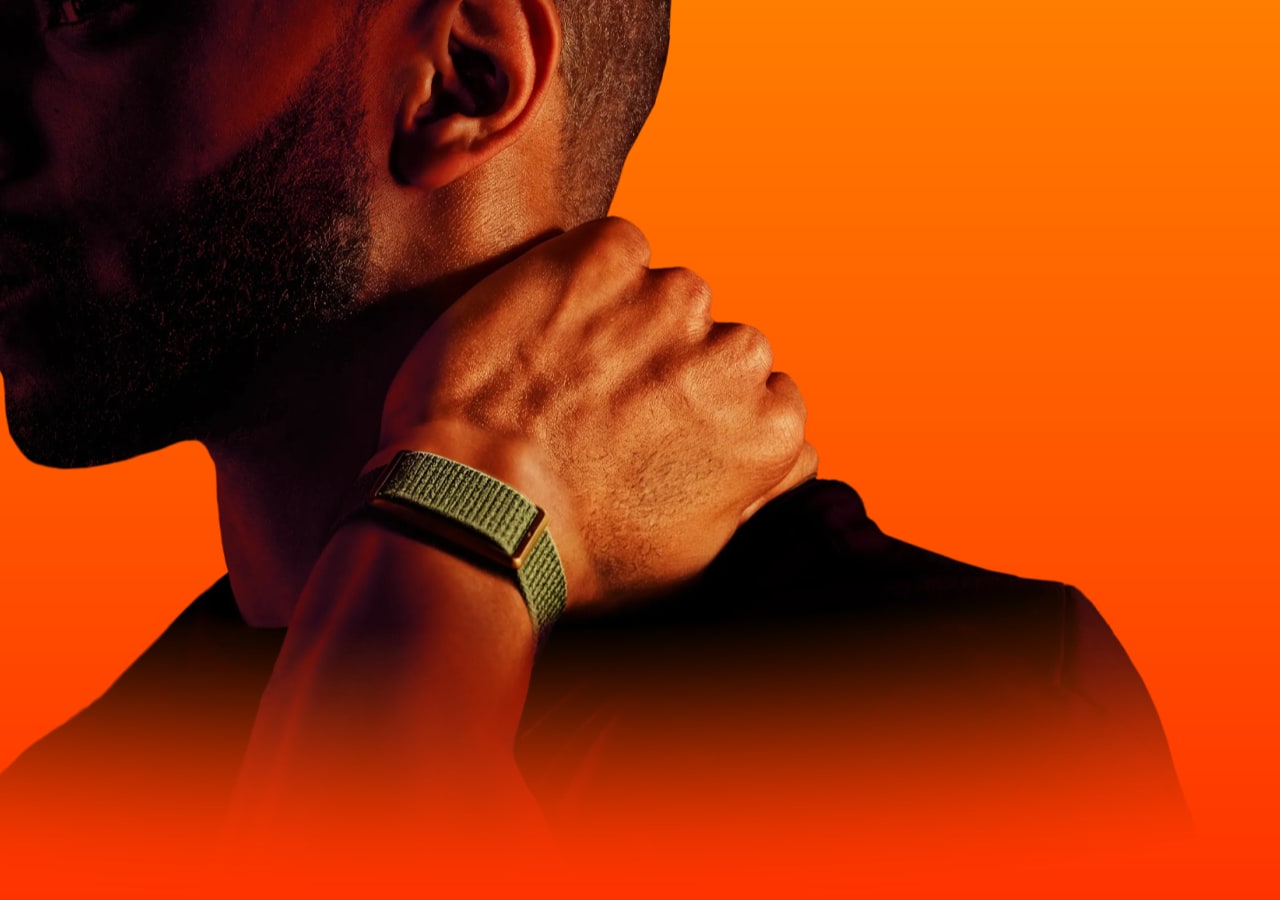 Homme avec montre verte, fond orange vif. polar loop