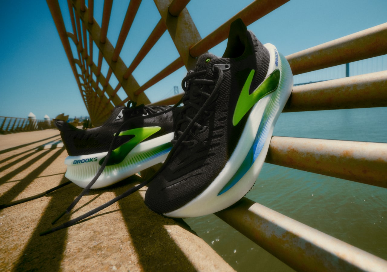 Chaussures de sport noires avec détails verts sur pont.