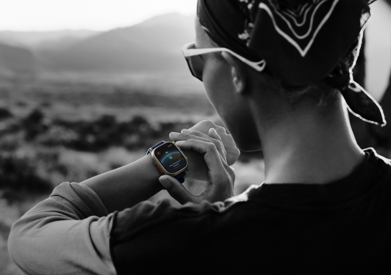 Personne vérifiant une montre connectée en extérieur.