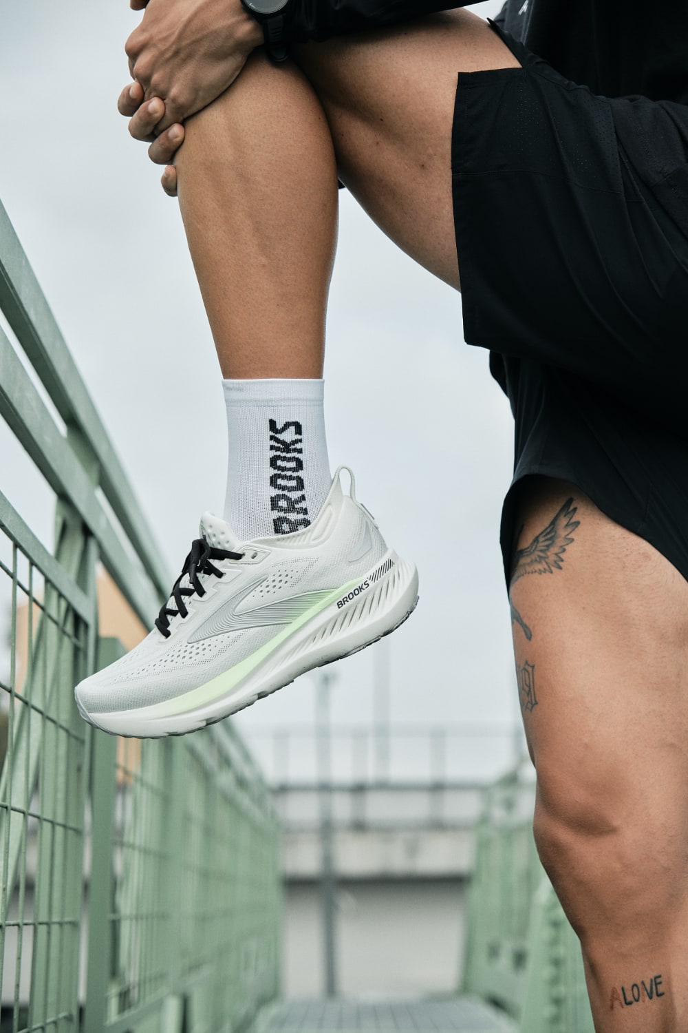 brooks glycerin gts 23 Homme portant chaussures de sport blanches sur pont.