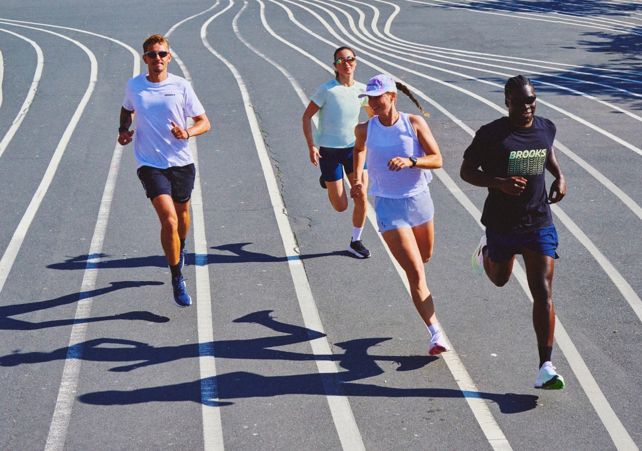 Quatre personnes courent sur une piste.