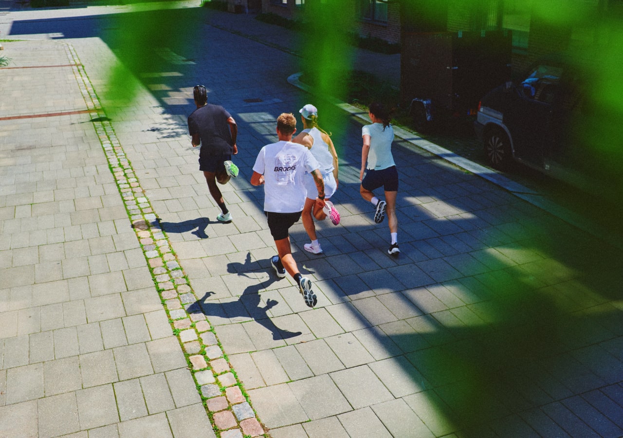 Quatre personnes courent ensemble dans la rue.