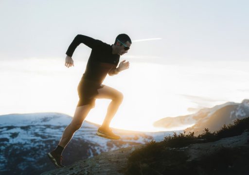 kilian jornet rejoint julbo Personne courant sur une montagne enneigée au lever du soleil.
