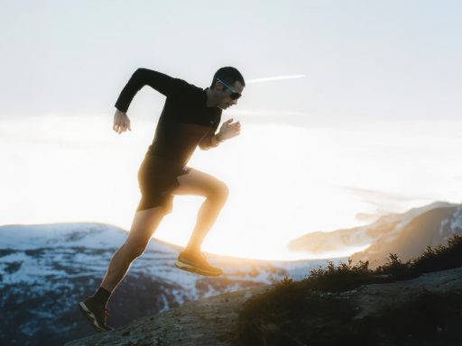 kilian jornet rejoint julbo Personne courant sur une montagne enneigée au lever du soleil.