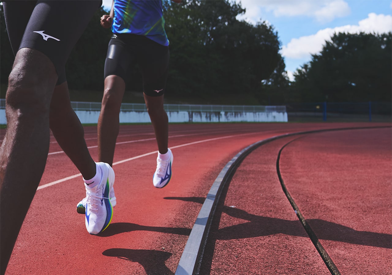 Deux coureurs sur piste d'athlétisme rouge.