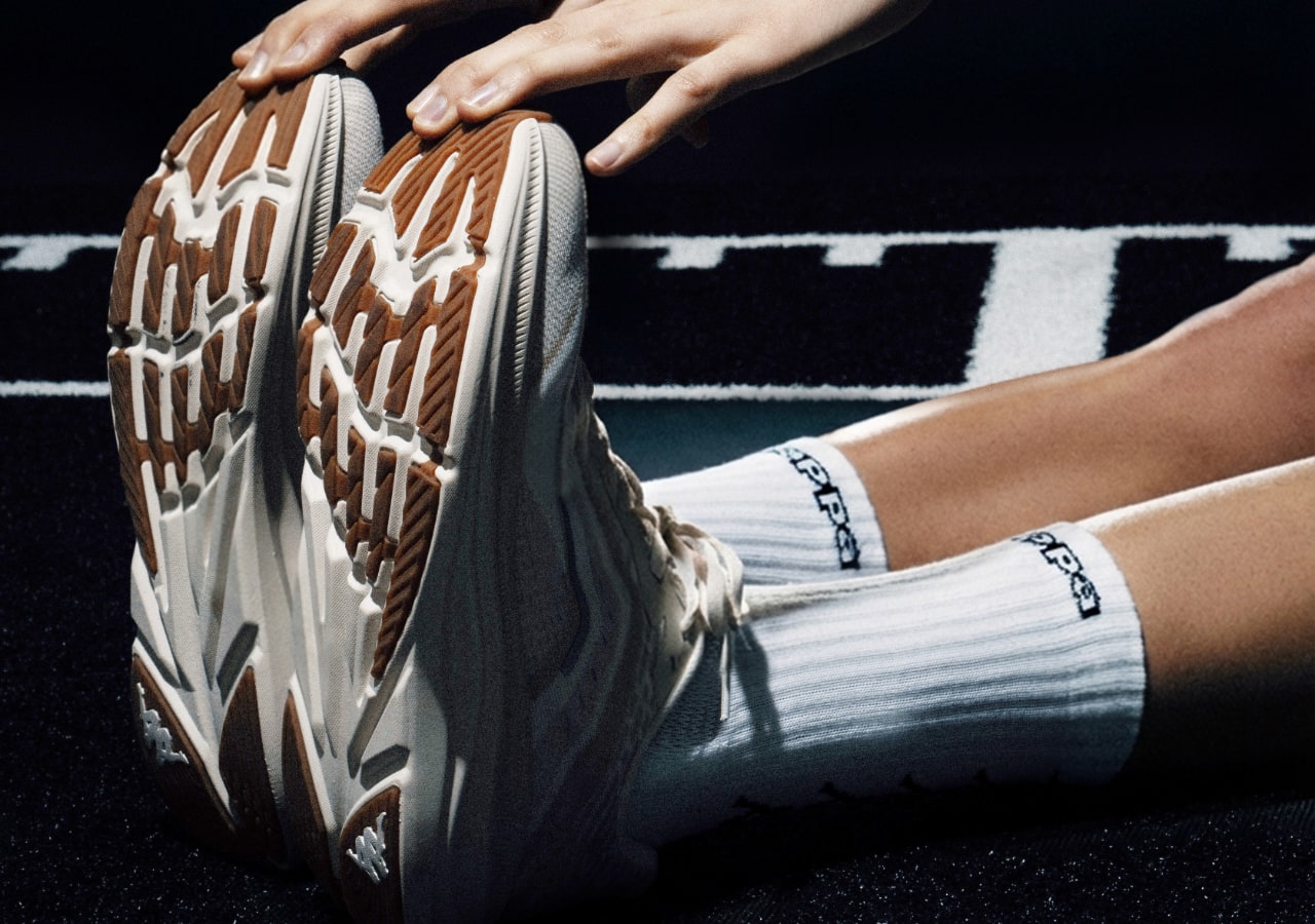 Personne s'étirant avec des baskets blanches