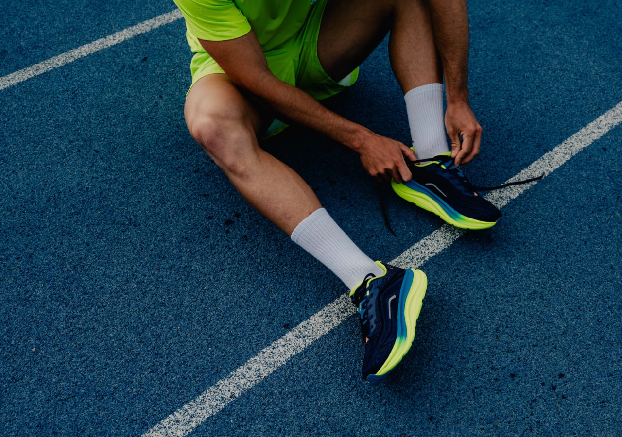 Athlète attachant ses lacets sur piste bleue