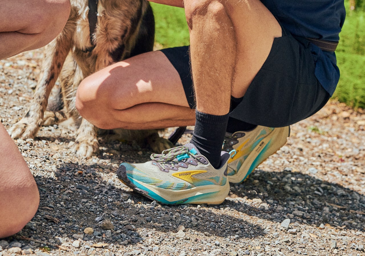 Homme agenouillé portant des chaussures de sport
