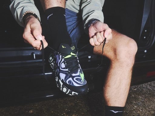 Lacing colorful running shoes in a car.