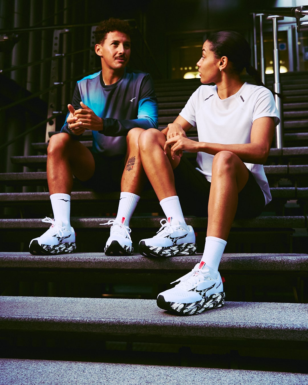 Deux sportifs assis sur des marches urbaines