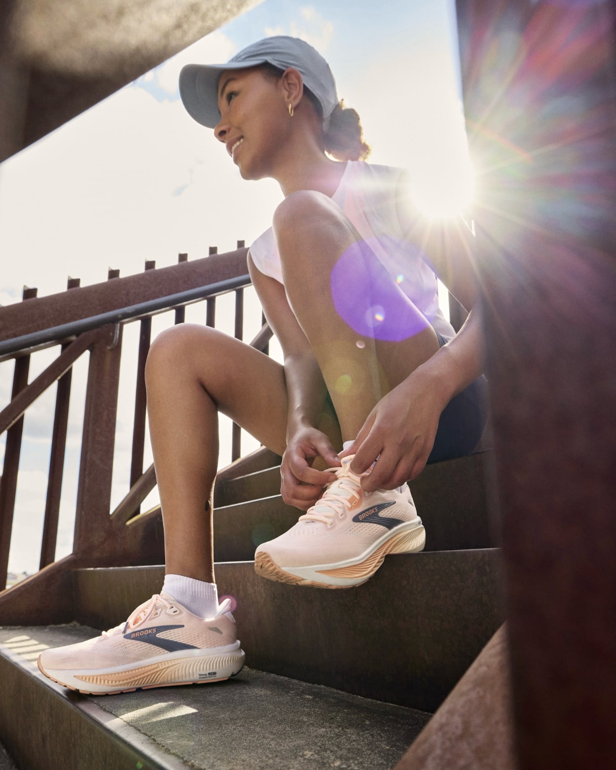 Femme attachant ses chaussures de running au soleil
