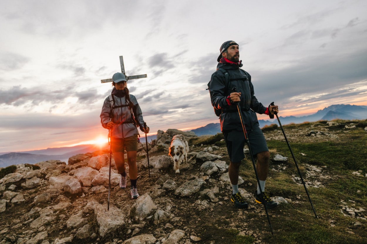 Randonneurs avec chien au coucher du soleil