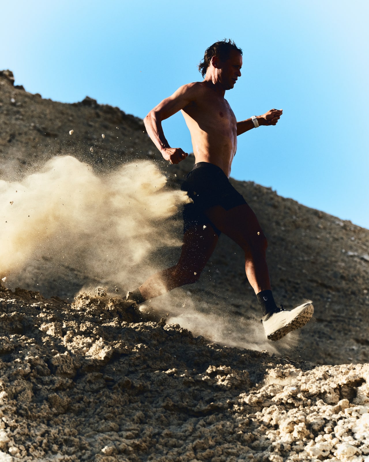 Coureur de trail dévalant une pente rocailleuse