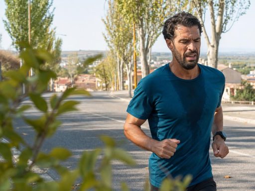 Homme courant sur une route bordée d’arbres