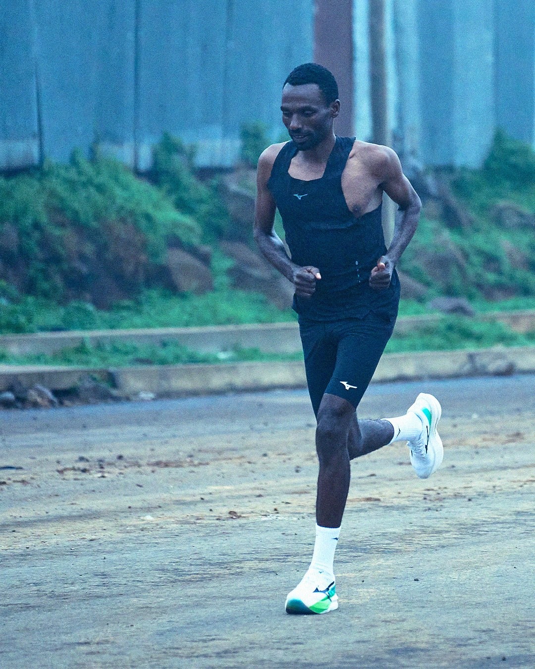Coureur en Mizuno Hyperwarp Pure 2 sur une route par temps brumeux